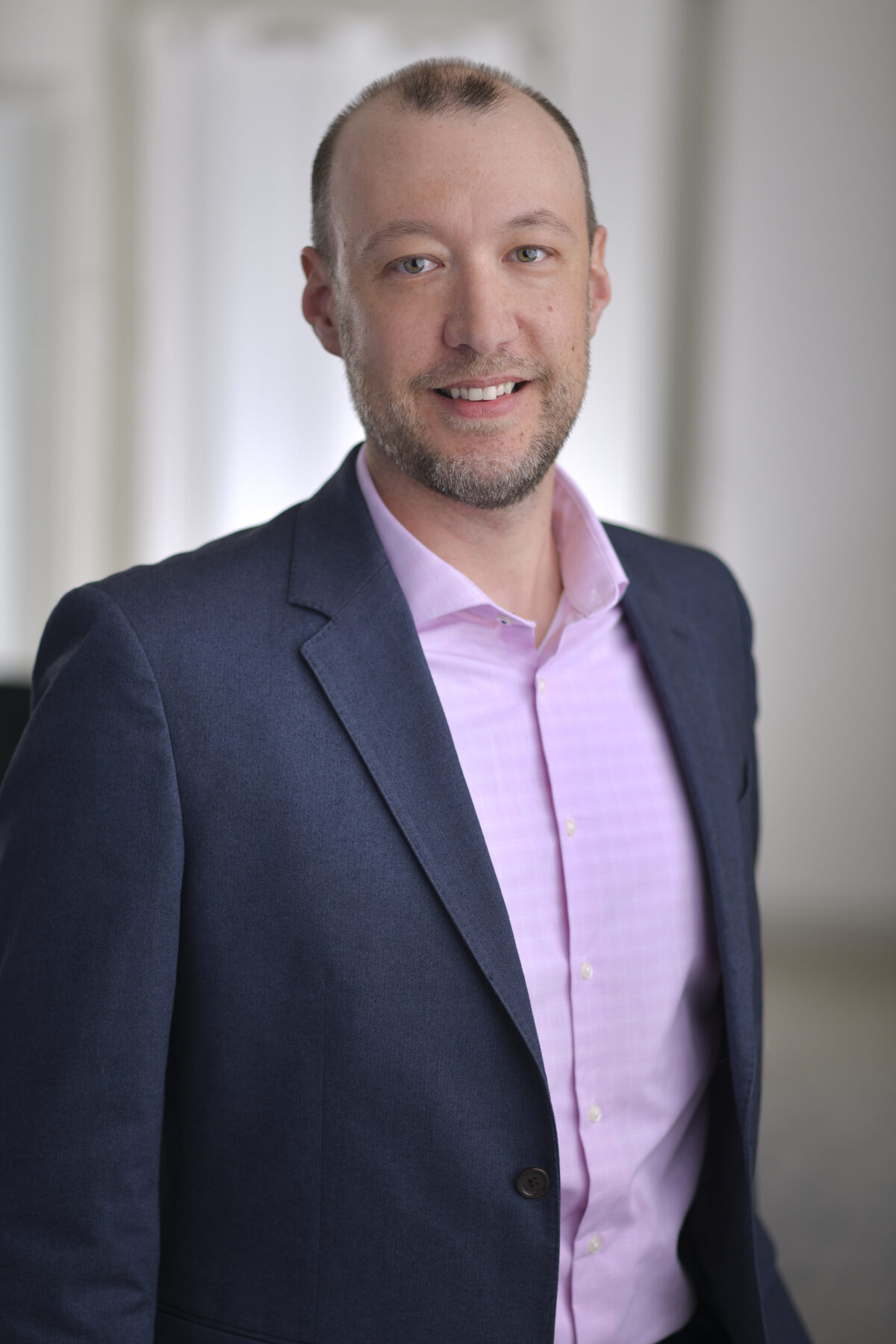 Simon Anderson professional portrait, navy jacket smiling
